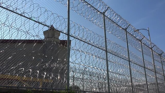 IOWA - 6.28.2024 - Establishing shot of the Iowa State Penitentiary seen through the barbed wire fence.