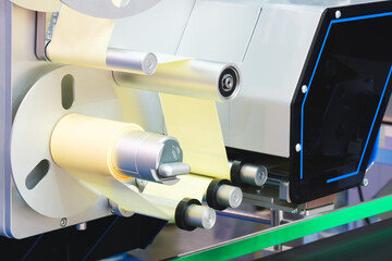 A roll of white paper is passed through the machine. printer and sticker machine, which is used for...
