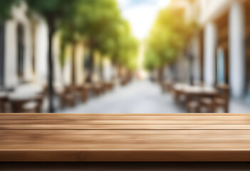 empty wooden table surface, place to display or place items - blurred outdoor café setting with tables and chairs along a street, lined with green trees and buildings