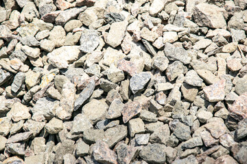 Close-up image of various sizes of grey and pink gravel stones
