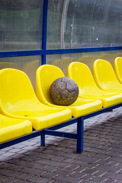 A vertical color photo, and a soccer ball rests on yellow plastic seats for the spectators of ndr and tsanopa.
