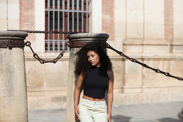 beautiful young latin woman with black and dark eyes and long curly hair with a sad expression...