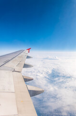 View from the airplane window at a beautiful cloudy sky and the airplane wing