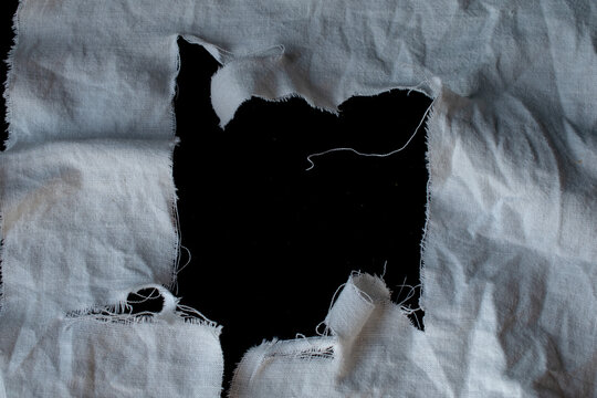 old torn white rag with black holes