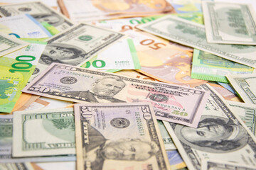 A scattering of US dollar bills and Euro banknotes on a white surface