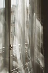 Soft play of light and shadow on translucent curtains in pastel tones evokes calm and serenity