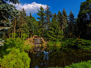 Fototapeta premium Landscape with cascading waterfall in scenic Skaryszewski Park in Warsaw, Poland