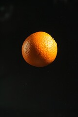 Fresh Seville Orange levitating on a black background