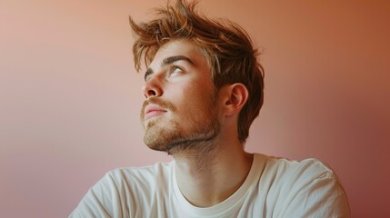 Obraz premium Serene Young Man Relaxing Against Soft Gradient Background
