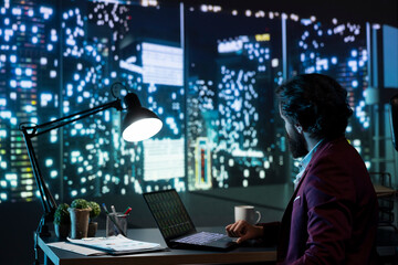 Private equity manager analyzing financial reports at night, examining investment transactions to help expand activity on international scale. Advisor follows stock market trends online.