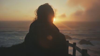 Fototapeta premium a person standing on a beach at sunset