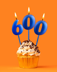 Blue candle number 600 - Birthday cupcake on orange background