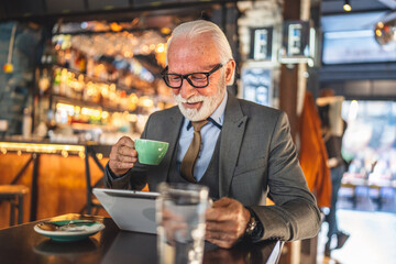 Senior man businessman business owner use digital tablet sit at cafe