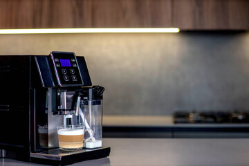 Modern coffee machine with glass cup of latte in kitchen