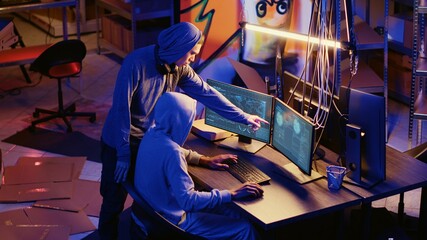 Hackers in underground bunker working together to take advantage of security breach after gaining...
