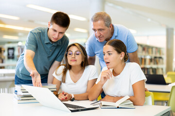 Fototapeta premium Group portrait of smiling positive engaged in research, working together in public library