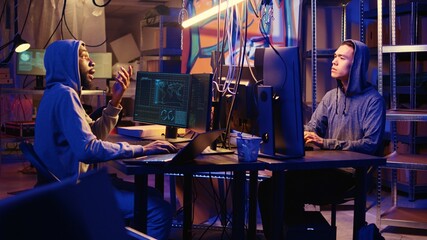 Hackers brainstorming ways to go undetectable by antivirus software installed on systems and successfully trick firewalls, discussing methods of developing zero day exploit in secret bunker