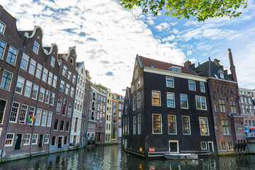 Amsterdam canal Singel with typical dutch houses and houseboats during morning blue hour, Holland, Netherlands.