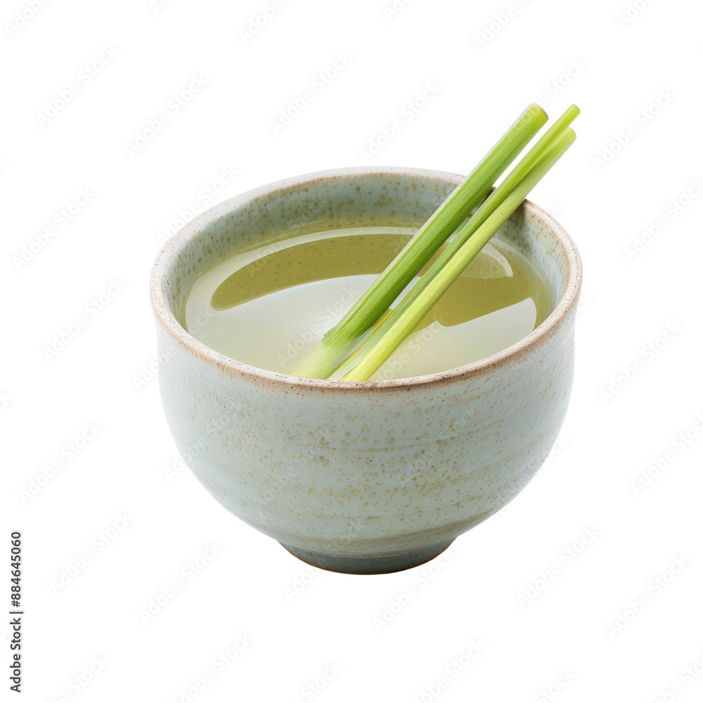 Wall mural a cup of lemongrass tea with two stalks of lemongrass. the tea is light green in color and the cup i