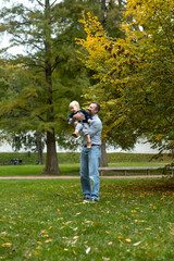 Young father with his son in the autumn park. The concept of a happy family.