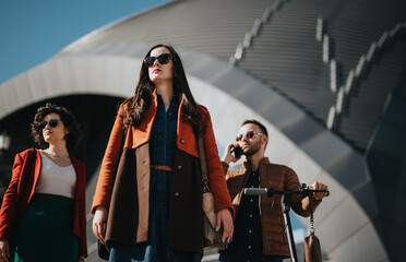 Three businesspeople or partners walking with purpose through an urban city area, showcasing modern work life on the go.