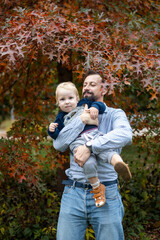 Young father with his son in the autumn park. The concept of a happy family.