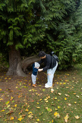 Fototapeta premium Young mother and her little son having fun in the autumn park.