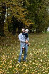 Obraz premium Young father with his son in the autumn park. The concept of a happy family.