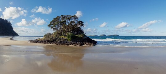 Rocky island on the shoreline beach of Opoutere, Whangamata, Coromandel Peninsula, New Zealand.