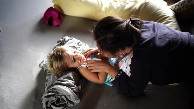 Mom tickles the little laughing girl tummy on the bed. High quality 4k footage
