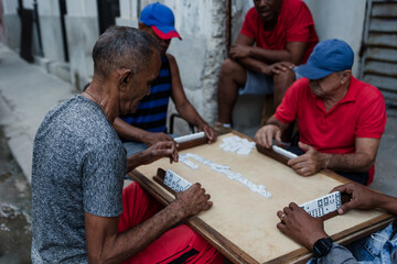 Latin group of elderly men playing dominoes in Old Havana Cuba, Caribbean black people	