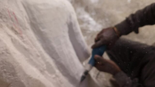Indian artisan carving an Modern Abstract Love Couple sculpture in styrofoam.
