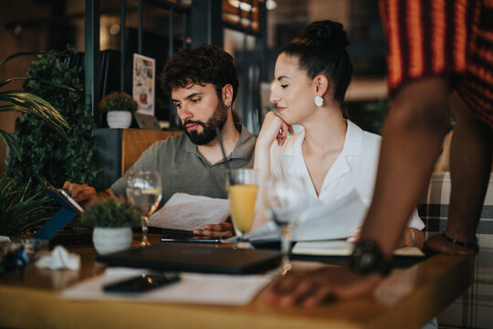 A diverse group of people engage in collaborative discussions at a coffee bar, working together in a relaxed meeting atmosphere.