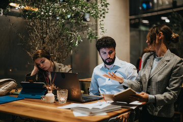 Startup team working together on a new project late at night in a casual coffee bar, focused on collaboration and brainstorming.