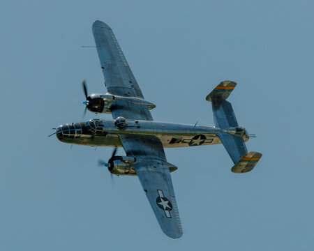 B-25 Miss Mitchell approaches from the right as it makes a low altitude pass with its left wing low