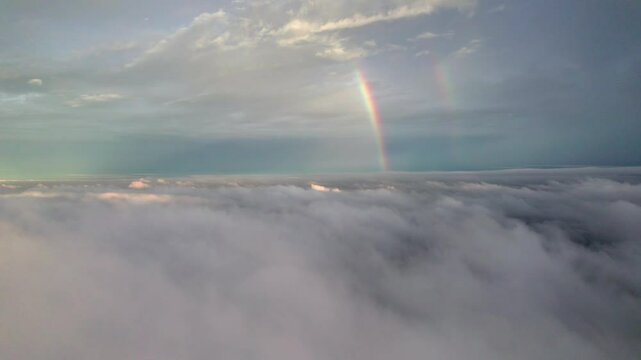 Aerial drone view of twin rainbows above white clouds with blue sky background during sunset, 4k real time footage b roll shot. Amazing high angle view rainbow.