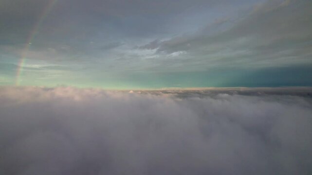 Aerial drone view of twin rainbows above white clouds with blue sky background during sunset, 4k real time footage b roll shot. Amazing high angle view rainbow.
