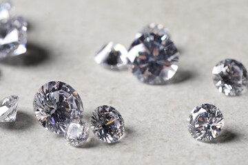 Many beautiful shiny diamonds on light background, closeup