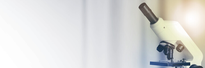 Microscope on blurred background, closeup. Banner design with space for text