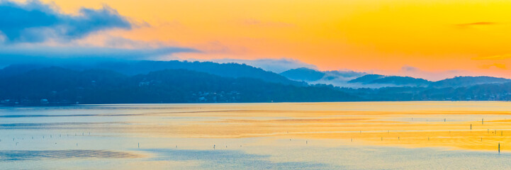 Sunrise over the calm water with boats and reflections