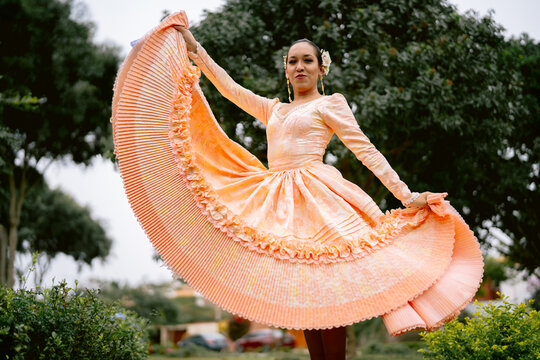 Peruvian woman dancing marinera in traditional outfit