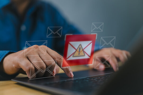 Person use laptop displays Email spam icon, junk, and e-marketing. Receive alerts for Email spam viruses. Caution, Internet letter security protection. Enhance online security.