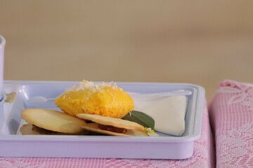 A set of Thai snacks, desserts, and coffee cups are placed on the table.