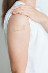 Woman with bandage after receiving vaccine. Vaccination and Immunization for Influenza, HPV, Zoster, IPD, DTP or Diphtheria, Tetanus and Pertussis, MMR, Hepatitis B, Covid  and Varicella vaccine