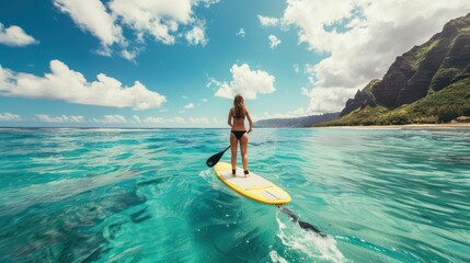Obraz premium Attractive young woman enjoying paddle surfing in the summer sea