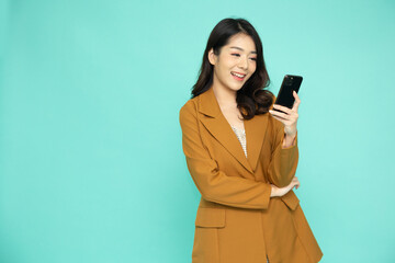 Young Asian woman scanning face using mobile application isolated on green background