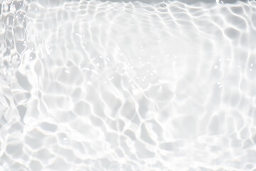 White water with ripples on the surface. Defocus blurred transparent white colored clear calm water surface texture with splashes and bubbles. Water waves with shining pattern texture background.