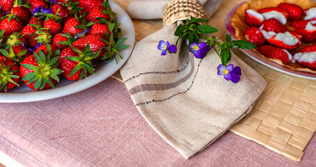 Spring forest flowers, strawberries and napkin on the table