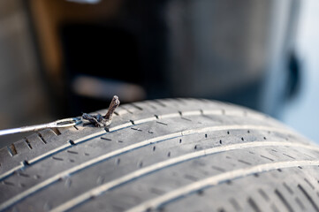 Repair plug being inserted to patch a nail tire puncture