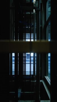 Modern glass elevator descending to the ground floor. Elevator going down.